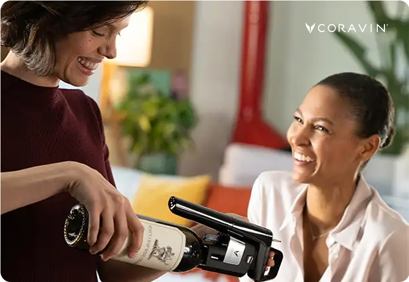 Two women laughing and enjoying wine using Coravin products.